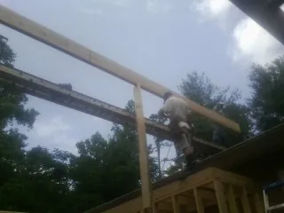 Carpenter setting a ridge beam over a new addition frame — Ice Dam Removal by Roofing Brothers in New Freeport