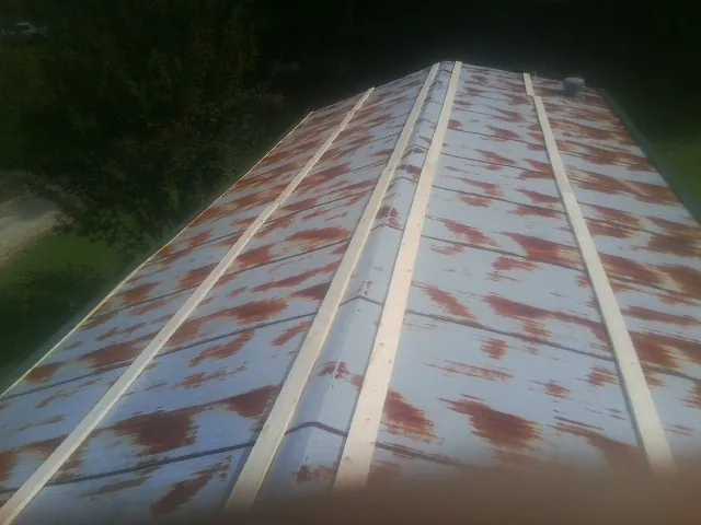 Rusted metal roof panels with new wood purlins before replacement — Storm Damage Roof Repair in New Freeport by Roofing Brothers