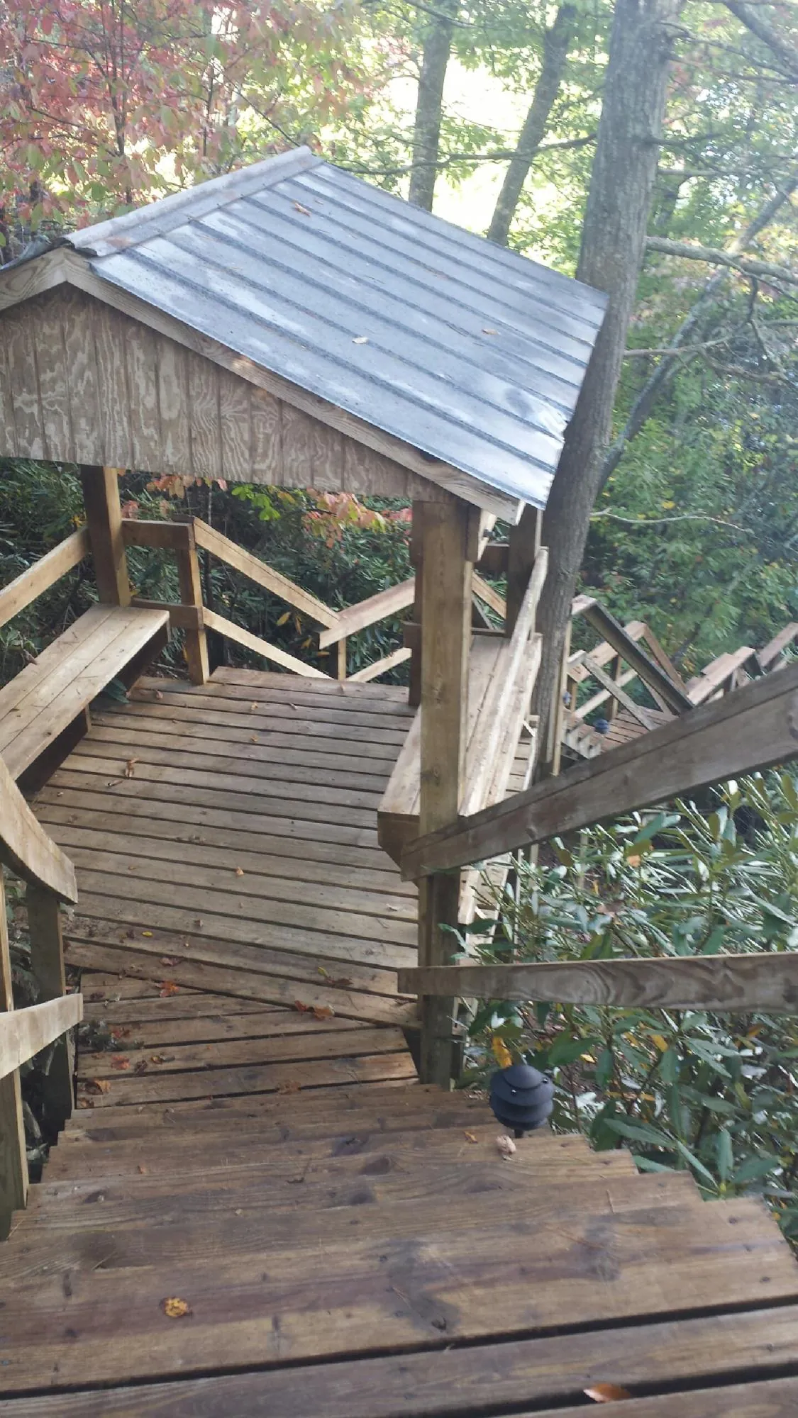 Metal roofed shelter over wooden steps on a wooded walkway — Skylight Repair & Installation work by our crew in New Freeport