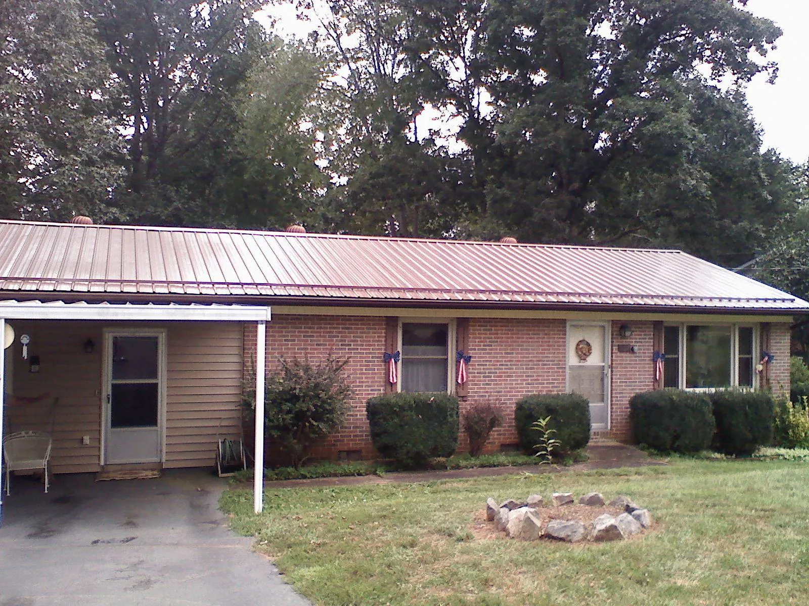 Bronze metal roof and carport on a brick ranch home — Roof Repair work by our crew in New Freeport
